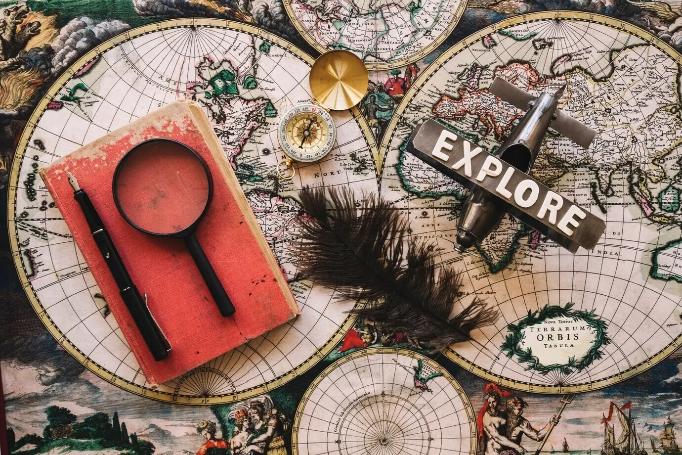 Feder in der Nähe eines Buches und von Reisesachen